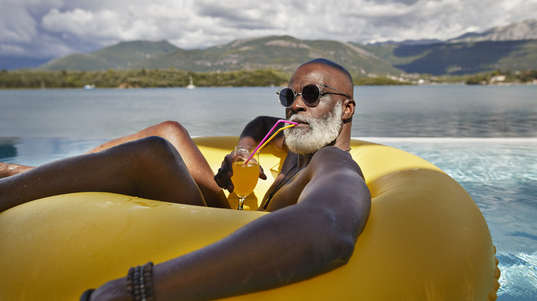 Older man relaxing in yellow tube on a beach