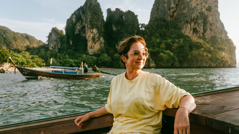 Women sitting in boat on ocean near island