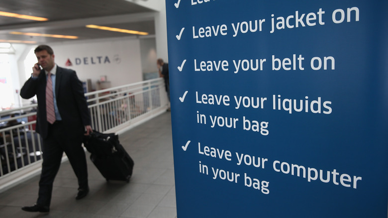 businessperson walking by TSA sign