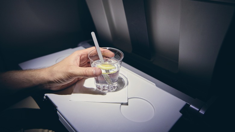 Passenger drinking gin on flight
