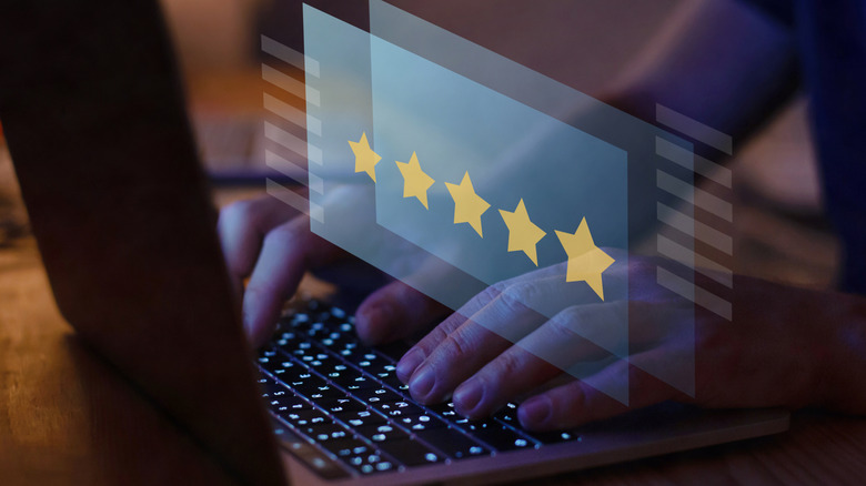 Person typing out a five-star review on a laptop