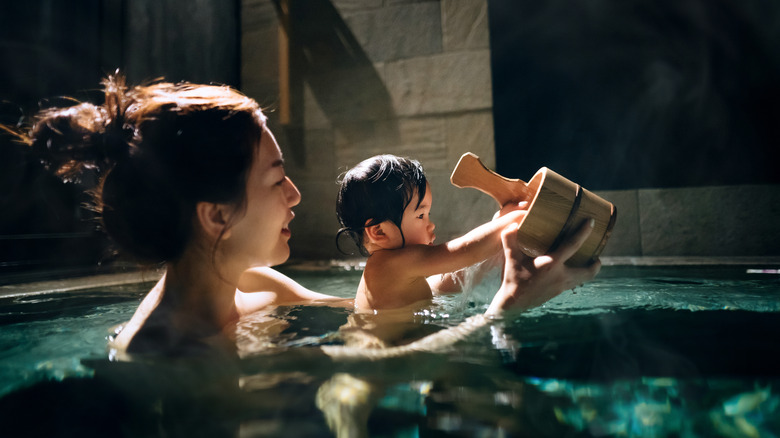 A mother and baby soak in an onsen together