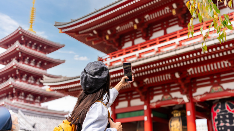 Woman taking photo at Japanese temple