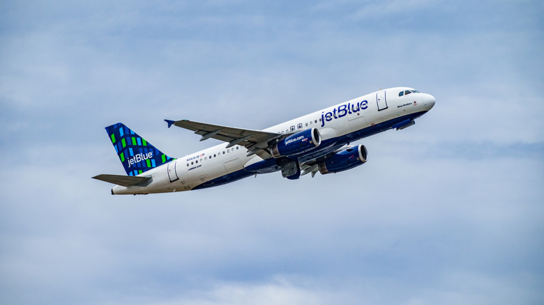 JetBlue plane in midair with sky background