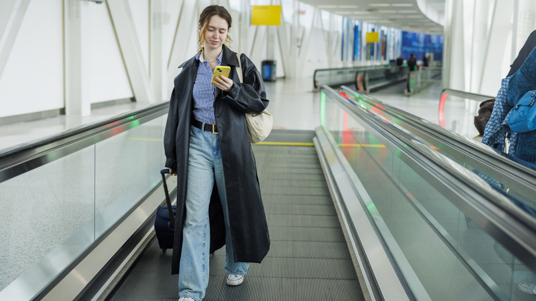 A traveler walks along an airport corridor.