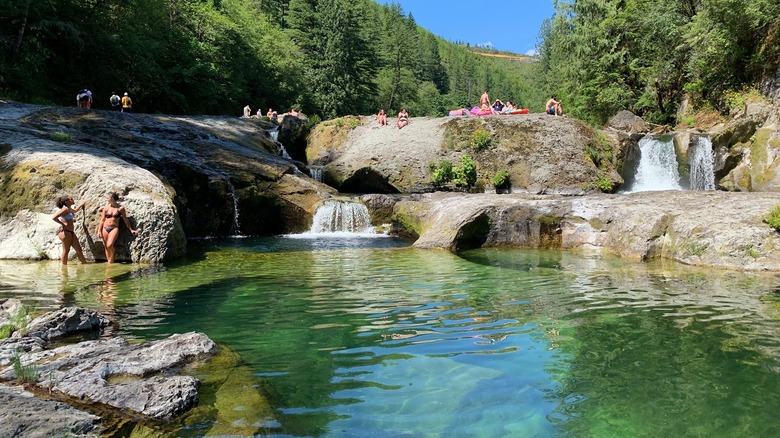 Visitors sunbathe and cooll of in the Washougal River at Naked Falls