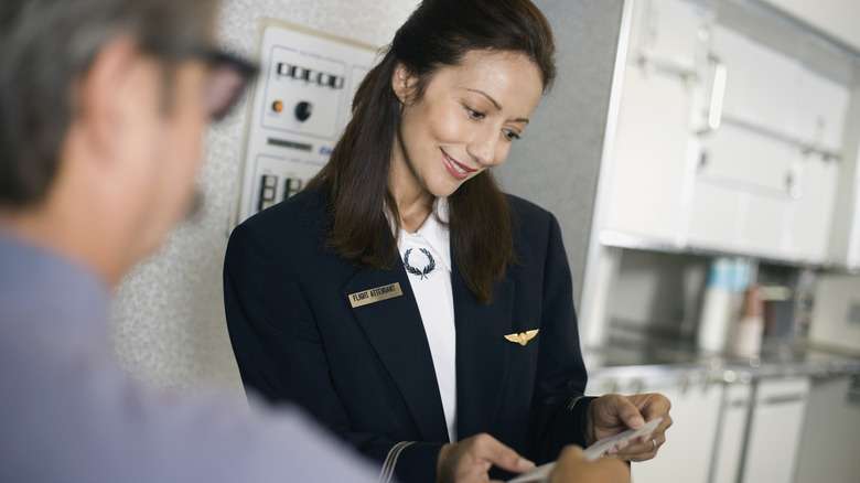 Flight attendant checking ticket