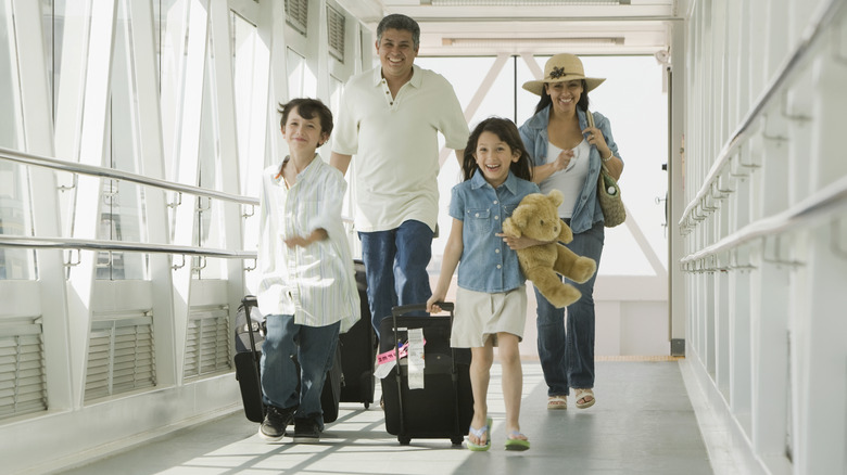 smiling family pulling luggage