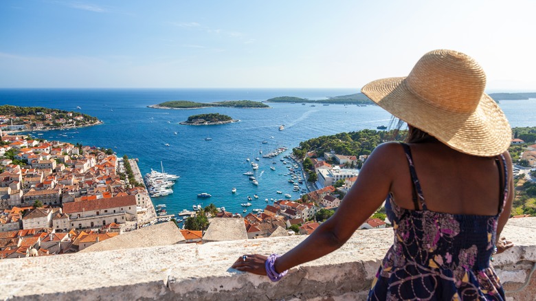 woman overlooking ocean and town