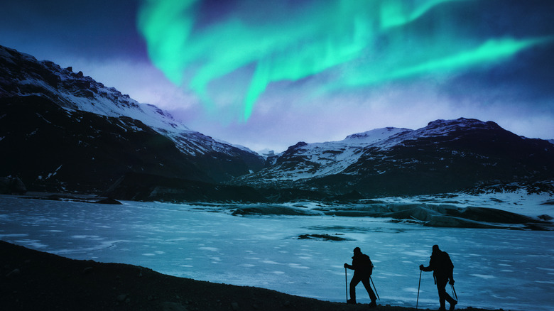 two hikers under Northern Lights