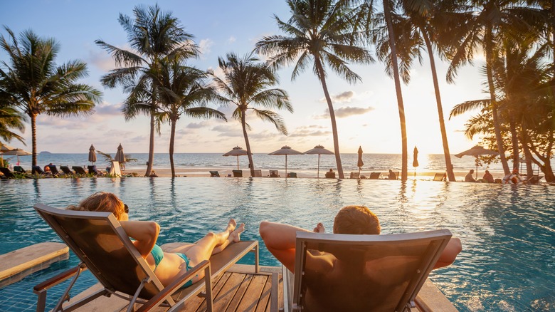 couple relaxing in poolside chairs