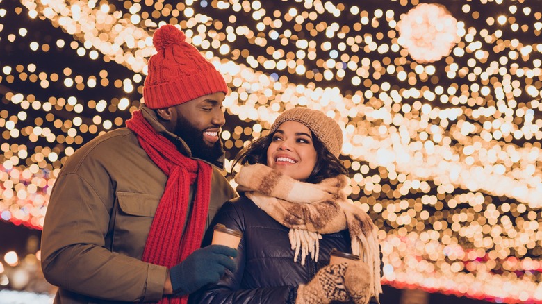 couple vacationing under Christmas lights