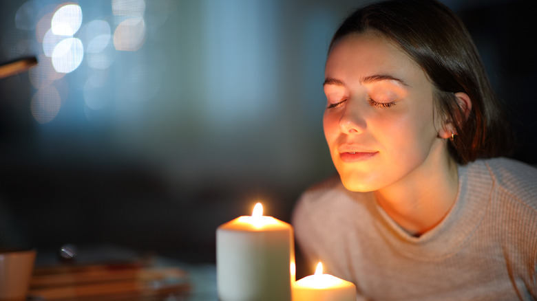 Woman smelling aromatherapy candles