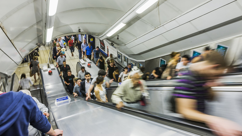 Commuters ride up an escalator in the London Underground