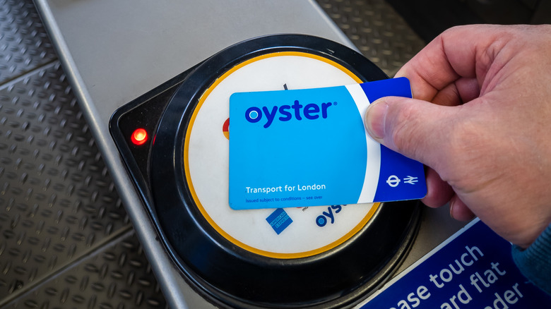 person holding oyster card at kiosk