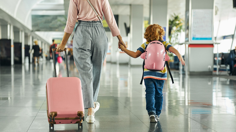 A mom and daughter walking in airport