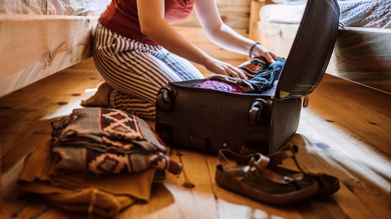 Woman unpacking a suitcase