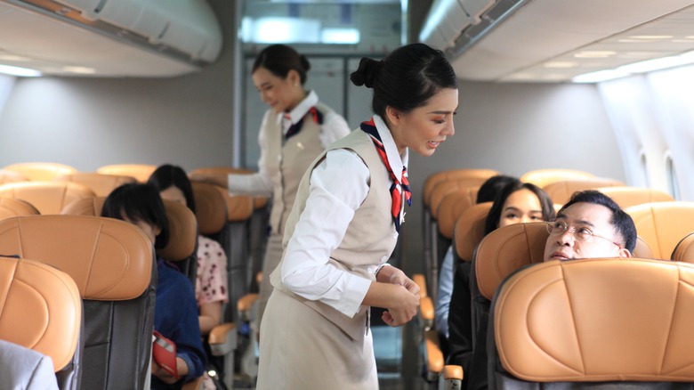 Flight attendant speaking with passenger