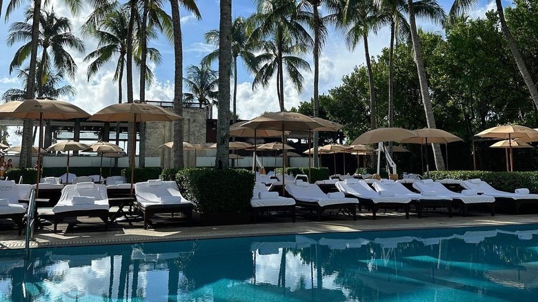 white lounge chairs by the pool