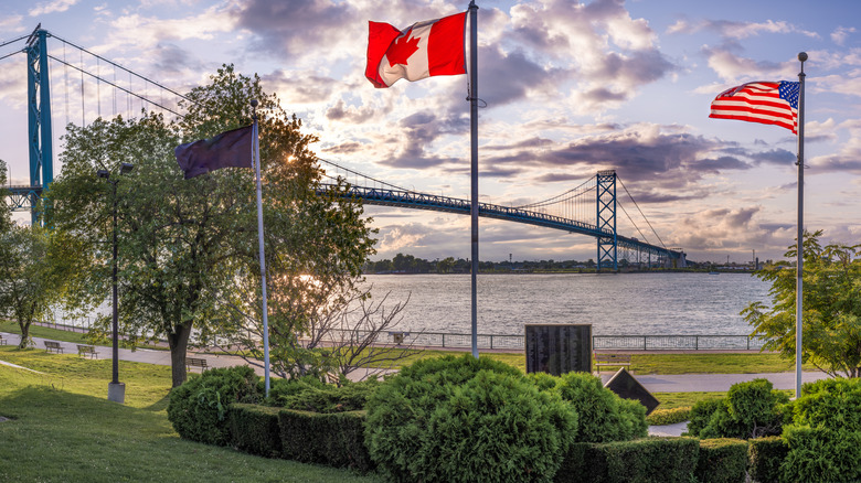 Canadian and American flags wave near the Ambassador Bridge