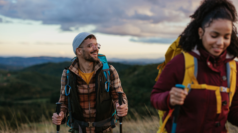 Smiling couple hiking with poles