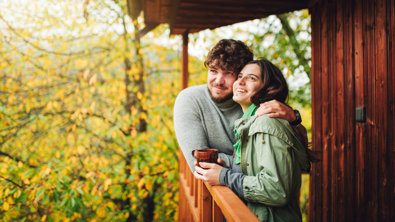 couple snuggling on cabin porch