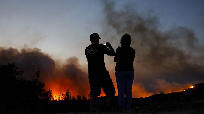 couple taking photos of wildfire
