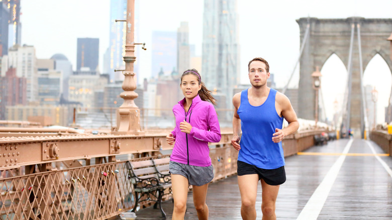 Two runners make their way across the Brooklyn Bridge