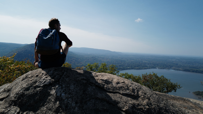 Person wearing backpack looking at view from Breakneck Ridge summit