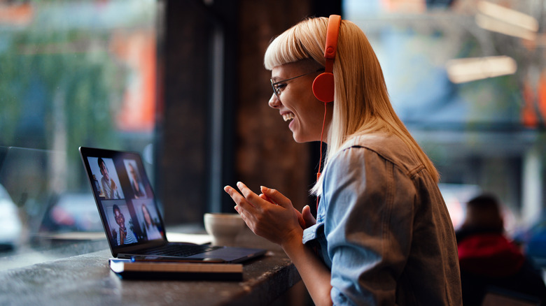 Woman laughs with colleagues on video call