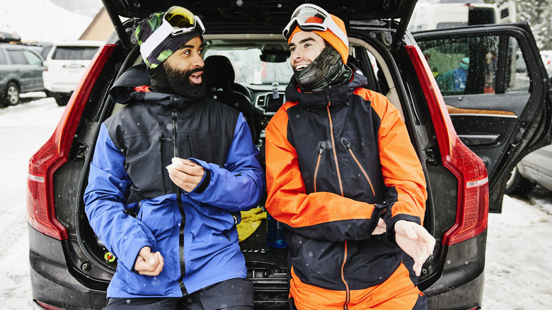 Two skiers resting by their car