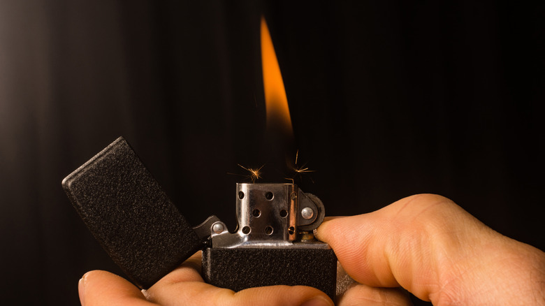 hand lights a Zippo lighter