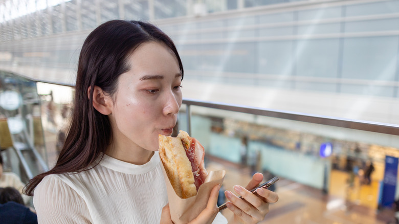 A woman eats her lunch at the airport