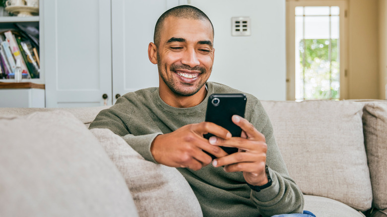 smiling man using smartphone