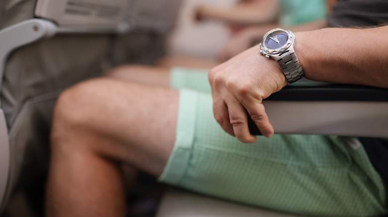 Nervous flyer gripping arm rests on plane