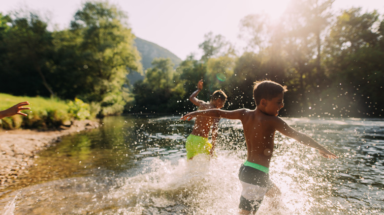 Two boys playing in the river on a hot summer day