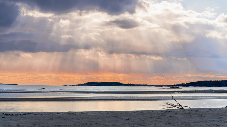 Sunlight penetrates clouds over Popham Beach, Maine