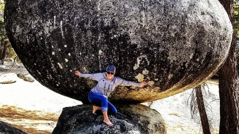 Person posing with globe rock