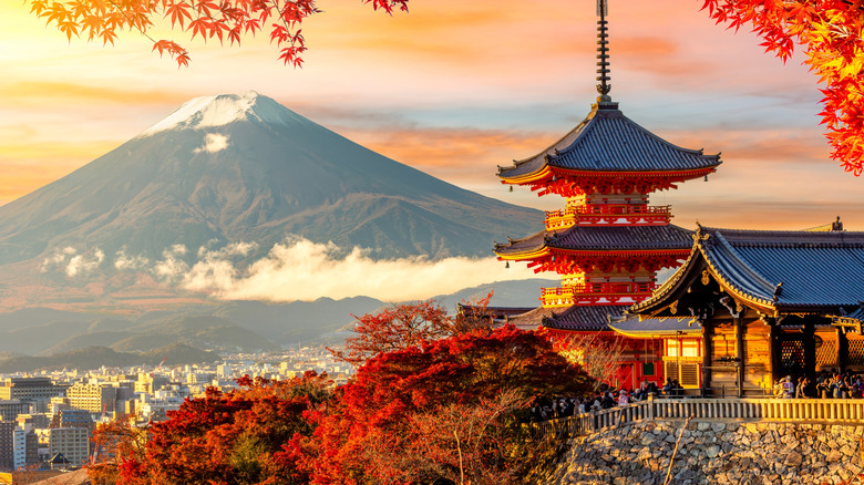 An ornate traditional pagoda rises over a scenic valley in Japan