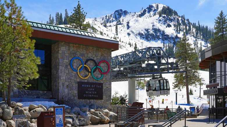 Building with the Olympic rings in Palisades Tahoe with mountains covered in snow in the background