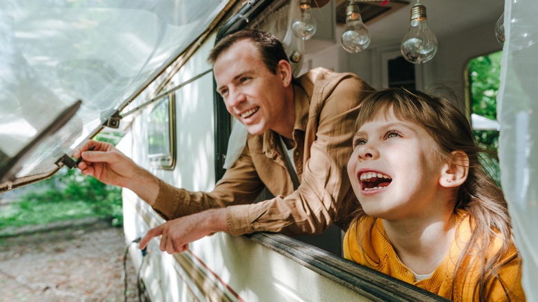 Family looking out camper window