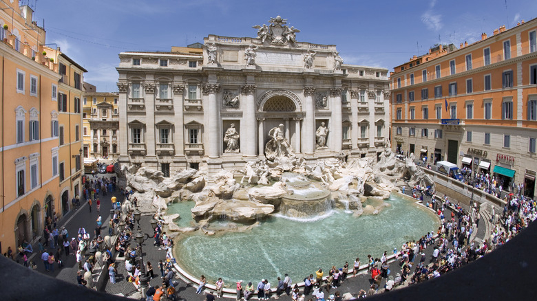 The Trevi Fountain in Rome surrounded by historic buildings and tourists.