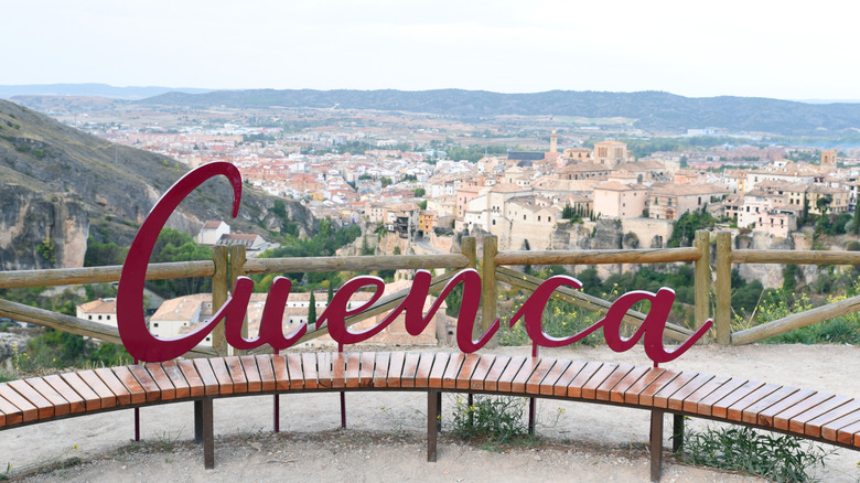 A playful sign for Cuenca, Spain, stands atop a hill