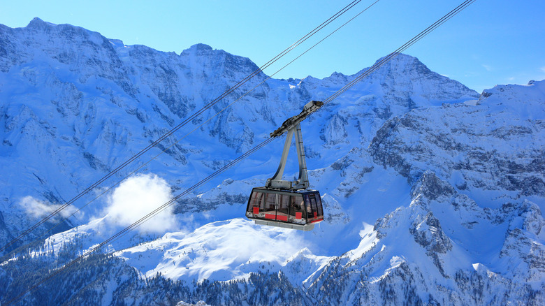 A cable car takes people high into the Swiss Alps