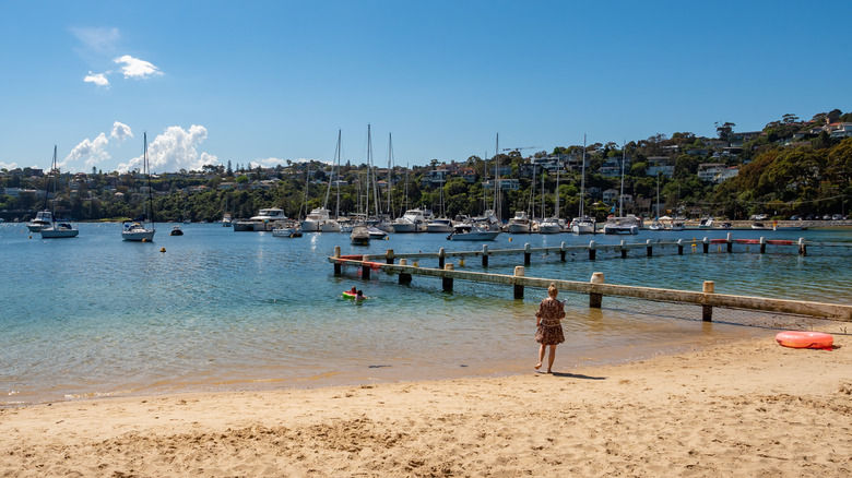 Women in dress standing at water's edge on Clontarf Beach