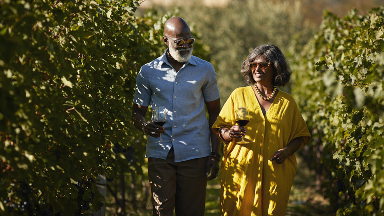 couple walking through vineyard