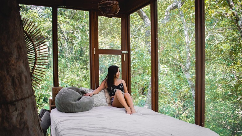 Woman on bed in a treehouse