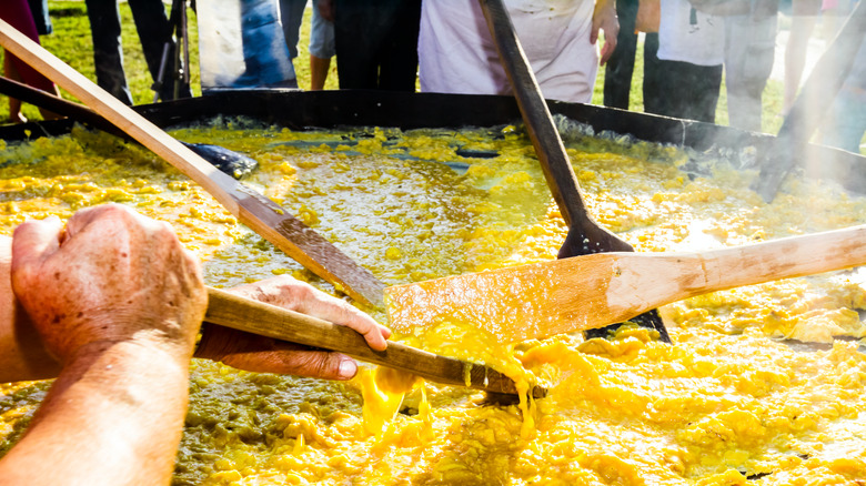 Men cooking a giant omelet in a pan