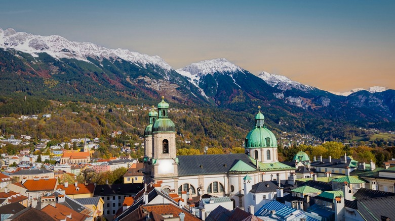 Mountains loom over Innsbruck houses and church