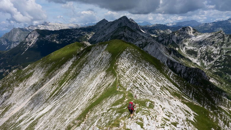 Solo hiker crosses a mountain crest